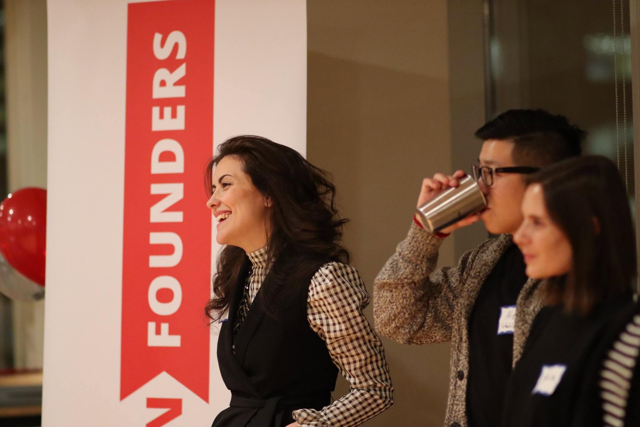 Founders laughing beside the InFounders banner