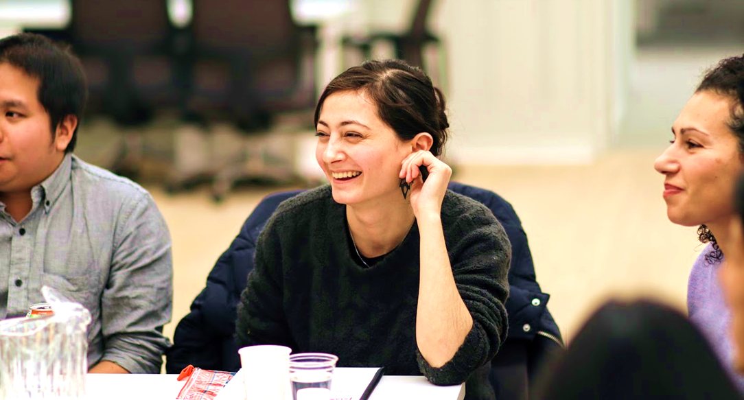 A founder laughing while her group listens